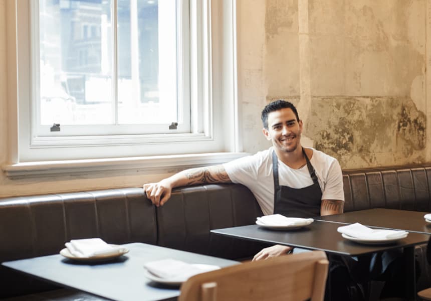 Chef Jesse Blake seated in a restaurant dining room